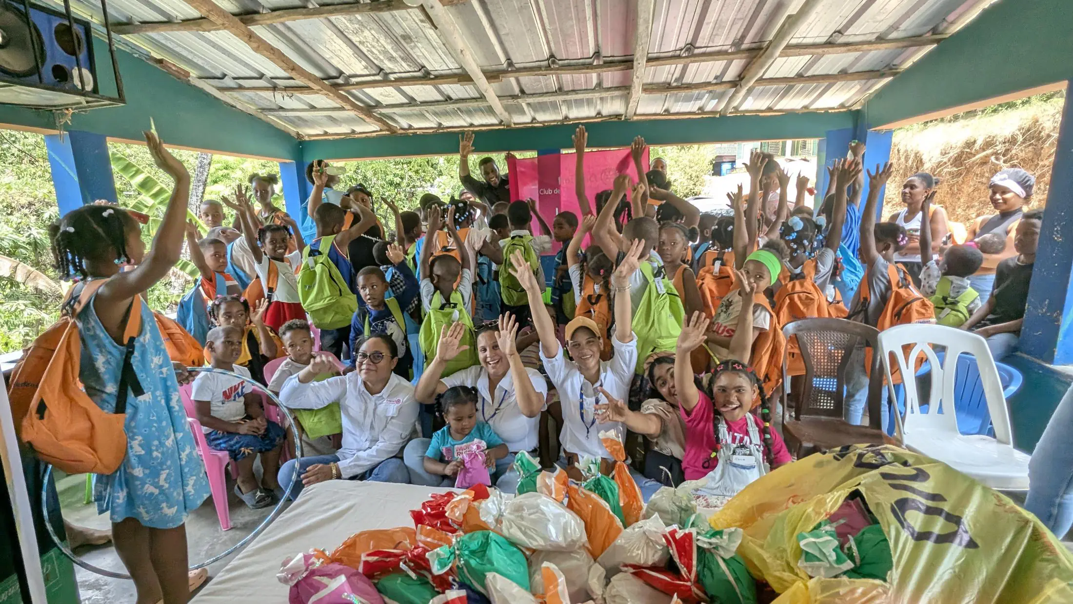 Niños celebran con las manos en alto durante una jornada de servicio