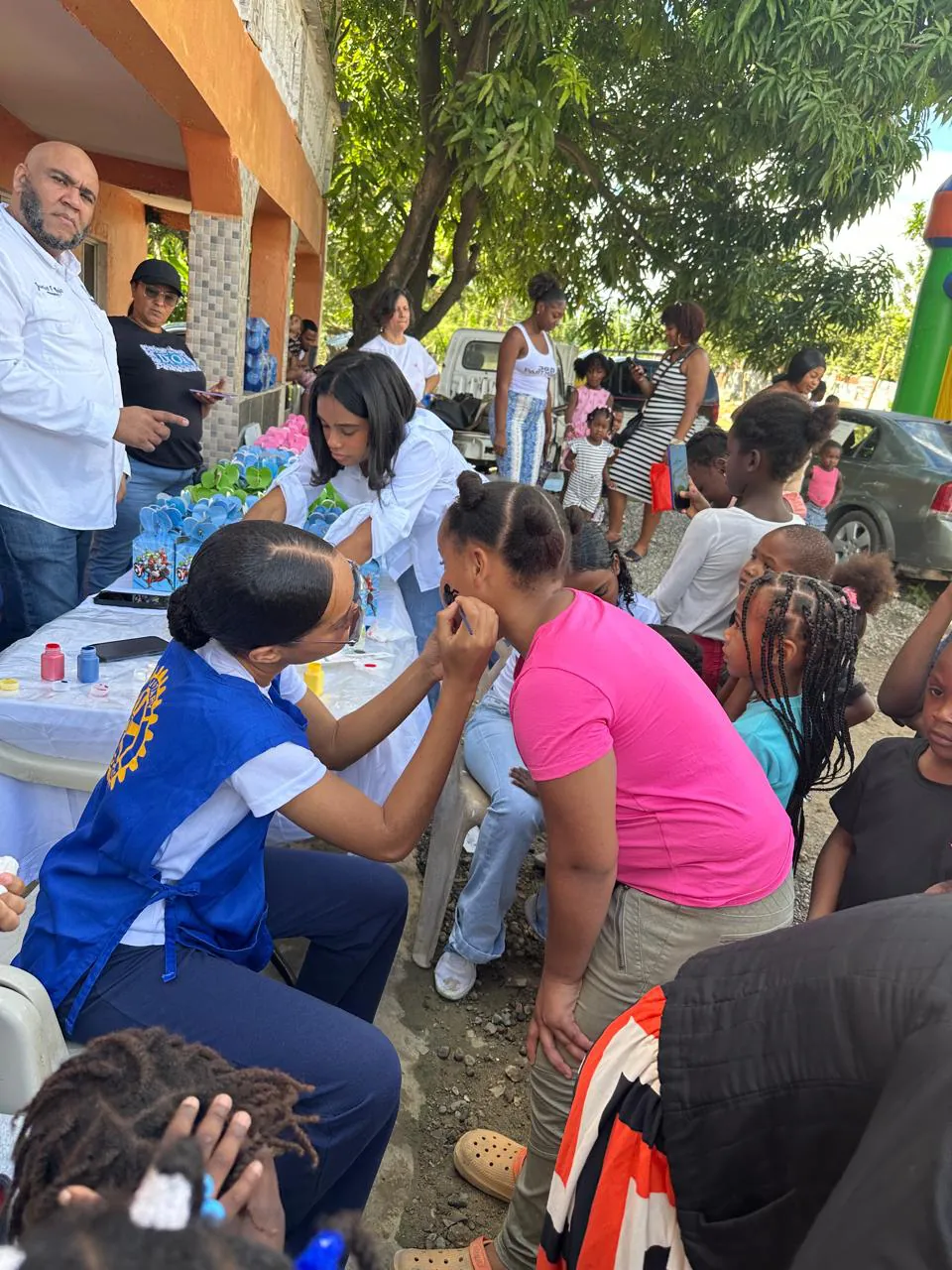 Jóvenes de Interact y una socia rotaria pintan caritas en una jornada con niños
